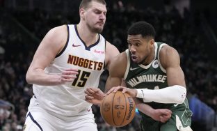 Milwaukee Bucks' Giannis Antetokounmpo tries to drive on Denver Nuggets' Nikola Jokic during the second half of an NBA basketball game Thursday, Feb. 27, 2025, in Milwaukee. (AP Photo/Morry Gash)
