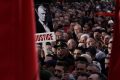 A man holds a banner depicting former Kosovo President Hashim in Skanderbeg square central Tirana, Albania, Friday, Oct. 17, 2025, as people protest against war crimes trials being pursued against some of their leaders in The Hague. (AP Photo/Vlasov Sulaj)