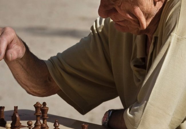 Old retired man playing chess at the Jardins du Luxembourg, Paris