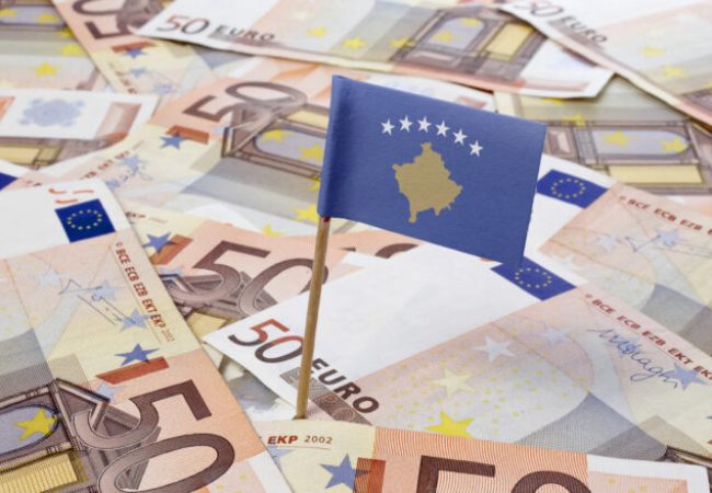 Flag of Kosovo sticking in european bank notes.